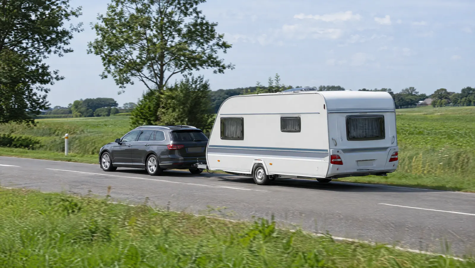 Bil med campingvogn på en dansk landevej